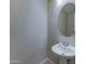 Powder room with a pedestal sink, oval mirror, and patterned wall at 26439 W Covey Ln, Buckeye, AZ 85396