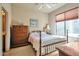 Charming bedroom with a four-poster bed, dresser, and a window with blinds at 3131 E Legacy Dr # 1104, Phoenix, AZ 85042