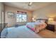 Cozy bedroom featuring a window with neighborhood views, a ceiling fan, and neutral decor at 3131 E Legacy Dr # 1104, Phoenix, AZ 85042