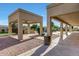 Large, covered patio and desert landscaping overlooking the custom pool and waterfall feature at 3531 E Norwood Cir, Mesa, AZ 85213