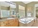 Elegant bathroom with granite counters, travertine tile, soaking tub, and natural light at 3531 E Norwood Cir, Mesa, AZ 85213