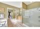 Elegant bathroom featuring a soaking tub, frameless shower and light wood cabinets at 3531 E Norwood Cir, Mesa, AZ 85213