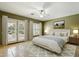 Bright bedroom featuring tile floors, a ceiling fan, a large window, and an upholstered bed at 3531 E Norwood Cir, Mesa, AZ 85213