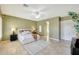 Bedroom featuring travertine tile flooring, neutral paint, ceiling fan, and ensuite bath at 3531 E Norwood Cir, Mesa, AZ 85213