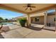 Inviting covered patio with a ceiling fan, offering a cool space for relaxation and outdoor enjoyment near the pool at 3531 E Norwood Cir, Mesa, AZ 85213