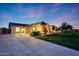 Well-maintained home with a spacious driveway, manicured lawn, and mature trees at twilight at 3531 E Norwood Cir, Mesa, AZ 85213