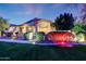 Beautifully landscaped front yard with green grass, vibrant bushes, and ample lighting at 3531 E Norwood Cir, Mesa, AZ 85213