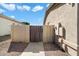 Side yard featuring a privacy gate, stone wall, and desert landscaping at 3531 E Norwood Cir, Mesa, AZ 85213