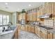Travertine-floored kitchen with stainless appliances, granite counters, and ample cabinets at 3531 E Norwood Cir, Mesa, AZ 85213