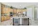 Kitchen features light wood cabinets, island, granite countertops, and travertine floors at 3531 E Norwood Cir, Mesa, AZ 85213