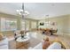 Open-concept living and dining areas featuring travertine tile, stylish lighting, and comfortable sofas at 3531 E Norwood Cir, Mesa, AZ 85213