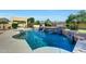 Refreshing pool with elegant waterfalls and mature landscaping, creating a serene backyard oasis for relaxation and enjoyment at 3531 E Norwood Cir, Mesa, AZ 85213