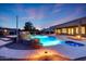Inviting pool with stacked stone waterfall feature, Baja shelf, and beautiful landscape lighting at 3531 E Norwood Cir, Mesa, AZ 85213