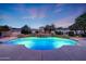 Backyard pool with a stone waterfall feature, ambient lighting, and lush greenery, perfect for evening swims and relaxation at 3531 E Norwood Cir, Mesa, AZ 85213