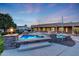 Tranquil pool and spa area with lush landscaping, stone pillars, and ambient lighting for a serene outdoor experience at 3531 E Norwood Cir, Mesa, AZ 85213