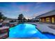 Outdoor pool features a stacked stone waterfall, adjacent to the covered porch, creating a private backyard oasis at 3531 E Norwood Cir, Mesa, AZ 85213