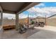 A covered patio with brick flooring, outdoor seating, planters, and string lights at 36284 W San Clemente Ave, Maricopa, AZ 85138