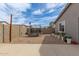 Open backyard featuring a trampoline, concrete patio, rock landscaping and string lights at 36284 W San Clemente Ave, Maricopa, AZ 85138