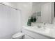 Neutral toned bathroom with white cabinets, mirror, and a shower at 36284 W San Clemente Ave, Maricopa, AZ 85138