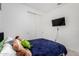 Bright bedroom features plush bedding, closet, and wall-mounted television at 36284 W San Clemente Ave, Maricopa, AZ 85138