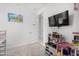 Bright bedroom features play kitchen, wall-mounted TV and a closet at 36284 W San Clemente Ave, Maricopa, AZ 85138