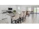 Modern open kitchen features a large island with bar stool seating, stainless appliances, and tile floors at 36284 W San Clemente Ave, Maricopa, AZ 85138