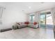 Spacious living room with sliding doors, tiled flooring, and neutral paint at 36284 W San Clemente Ave, Maricopa, AZ 85138