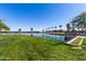 Scenic pond with lush green lawn and palm trees, perfect for relaxation at 36284 W San Clemente Ave, Maricopa, AZ 85138