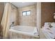 Bright bathroom featuring a tiled whirlpool tub, shower, and neutral color palette at 36601 N Mule Train Rd # 40A, Carefree, AZ 85377