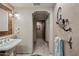 Unique bathroom featuring a pedestal sink, unique wall decor, and tiled floors at 36601 N Mule Train Rd # 40A, Carefree, AZ 85377