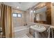 Bright bathroom with a bathtub, shower, sink, and decorative mirror at 36601 N Mule Train Rd # 40A, Carefree, AZ 85377