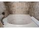 Large white soaking bathtub with jets and a chrome faucet with neutral colored tile at 36601 N Mule Train Rd # 40A, Carefree, AZ 85377