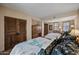 Comfortable bedroom featuring two beds with unique patterned linens, and custom wood closet doors at 36601 N Mule Train Rd # 40A, Carefree, AZ 85377
