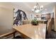 Close up of the dining room table featuring a chandelier and art piece of a Native American on the wall at 36601 N Mule Train Rd # 40A, Carefree, AZ 85377