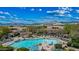 Aerial view of a community pool with mountain views, sun loungers, and landscaped surroundings at 36601 N Mule Train Rd # 40A, Carefree, AZ 85377