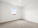 Well-lit bedroom with neutral carpet, a window for natural light, and electrical outlets on the wall at 37342 W San Clemente St, Maricopa, AZ 85138