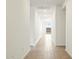 Bright hallway with wood-look tile flooring leading to backyard views, showcasing a modern, streamlined design at 37342 W San Clemente St, Maricopa, AZ 85138