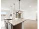 Elegant kitchen island with stainless dishwasher and modern faucet overlooking open floor plan at 37342 W San Clemente St, Maricopa, AZ 85138