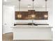 Spacious kitchen with granite counters, dark wood cabinets, and pendant lights at 37342 W San Clemente St, Maricopa, AZ 85138