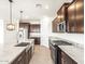 Modern kitchen with dark wood cabinetry, stainless steel appliances, and granite countertops at 37342 W San Clemente St, Maricopa, AZ 85138