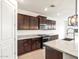Well-equipped kitchen featuring dark wood cabinets, granite counters, and stainless appliances at 37342 W San Clemente St, Maricopa, AZ 85138