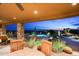 Spacious covered back patio with views of the pool and city lights at dusk at 41688 N 111Th Pl, Scottsdale, AZ 85262
