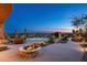 Stunning backyard featuring a cozy fire pit, desert landscaping, and sparkling pool with beautiful sunset views at 41688 N 111Th Pl, Scottsdale, AZ 85262