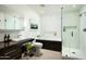 A modern bathroom with wood stained cabinets, a glass enclosed shower, and a soaking tub at 41688 N 111Th Pl, Scottsdale, AZ 85262