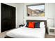 Bright bedroom with large windows, neutral tones, and orange accent pillows. A dark wooden double door can be seen at 41688 N 111Th Pl, Scottsdale, AZ 85262