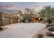 Home exterior showcasing a two car garage, desert landscaping, and entry gate at 41688 N 111Th Pl, Scottsdale, AZ 85262