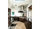 Gourmet kitchen features stainless steel appliances, dark wood cabinets, granite countertops, and a stylish range hood at 41688 N 111Th Pl, Scottsdale, AZ 85262