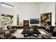 Inviting living room with fireplace, comfortable seating, and a large window offering picturesque outdoor views at 41688 N 111Th Pl, Scottsdale, AZ 85262