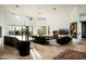 Open living room with fireplace, high ceilings, modern decor, and seamless transition to kitchen at 41688 N 111Th Pl, Scottsdale, AZ 85262