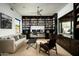 Home office with extensive built-in bookshelves and a comfortable seating area at 41688 N 111Th Pl, Scottsdale, AZ 85262